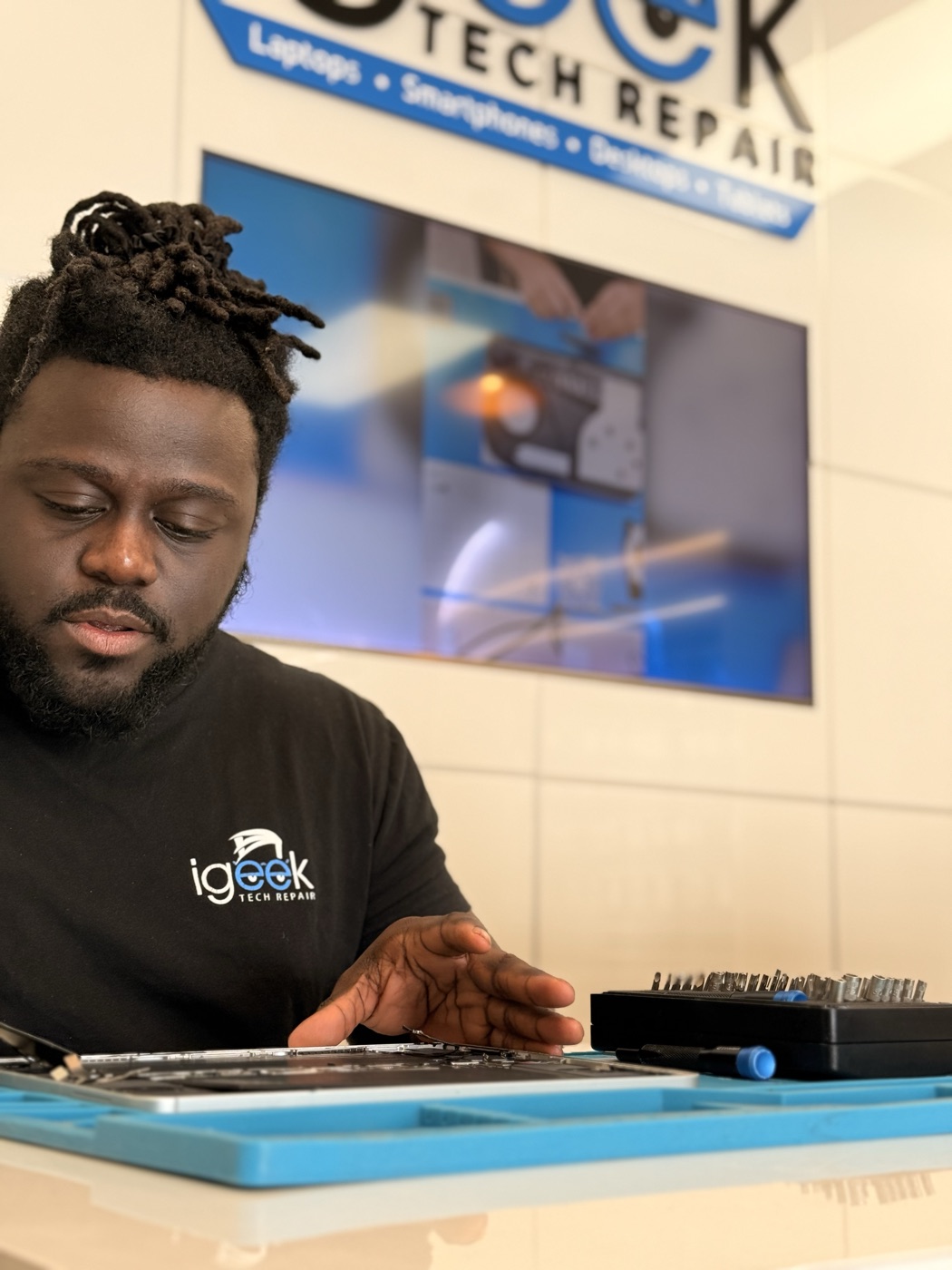 Trenton repairing a device at the iGeek front counter